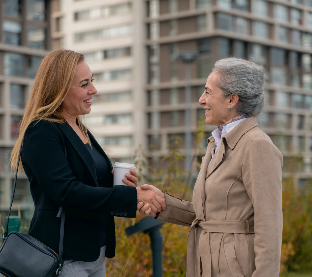 Women shaking hands outdoors